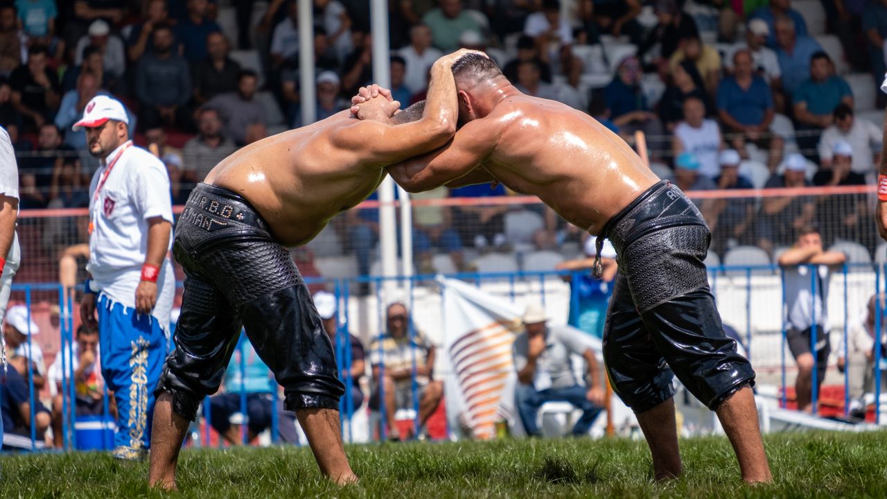 Two athletes engaged in a traditional oil wrestling match in Elmalı, Antalya.