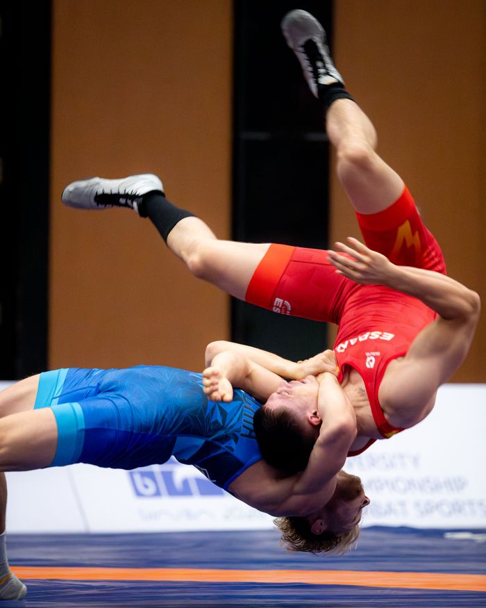 Two wrestlers engaged in an intense freestyle wrestling match, showcasing athleticism and technique.